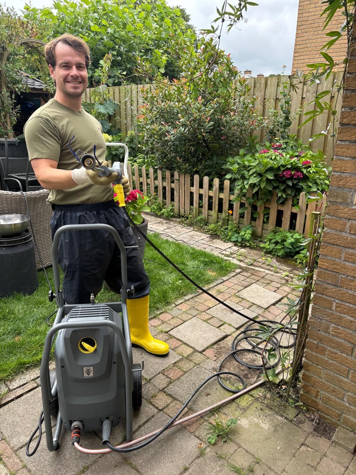 Henry met zijn hogedrukreiniger in de tuin, klaar om te beginnen