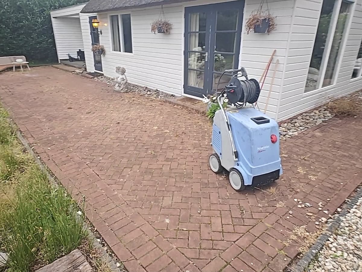 Groot terras met doffe, vervuilde klinkers vóór de behandeling