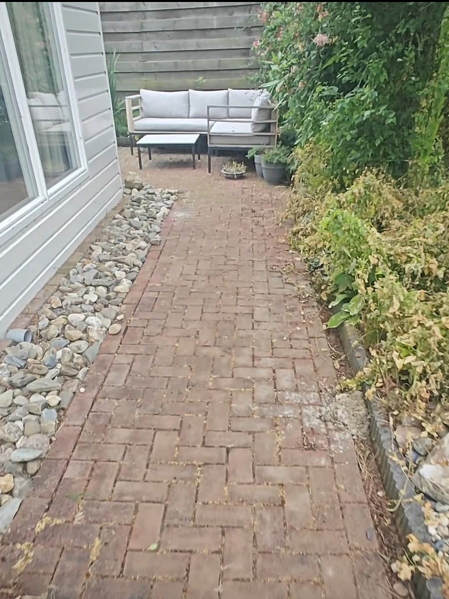Tuinpad langs de woning met vuil en aanslag tussen de klinkers, vóór de behandeling